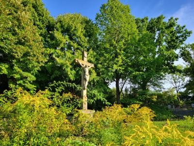 Großes Kreuz mit Korpus, von der Abendsonne beleuchtet.