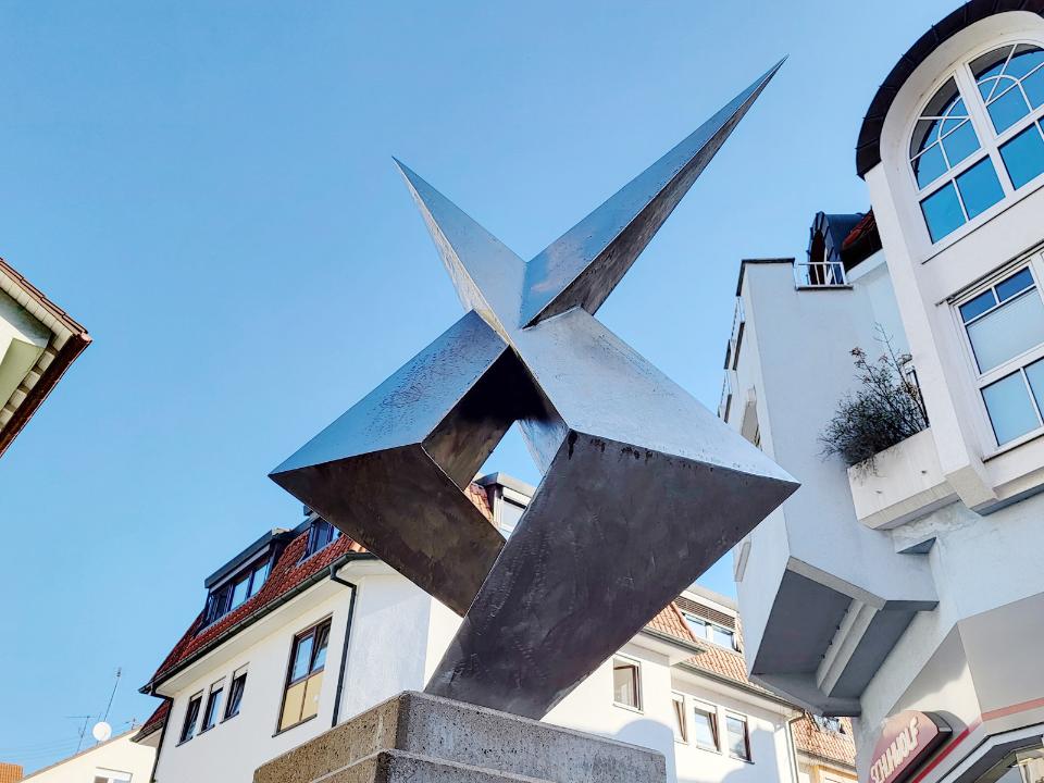 Kantige Edelstahl-Skulptur mit zum Himmel strebenden Spitzen.