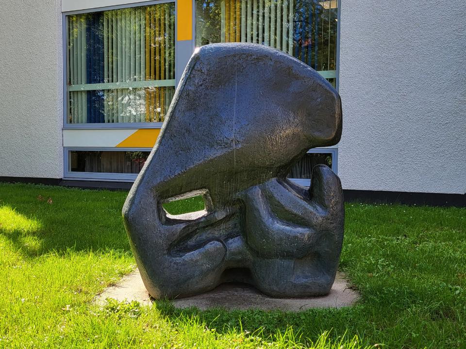 Abstrakte Bronzeskulptur einer Tiermutter mit Jungen.