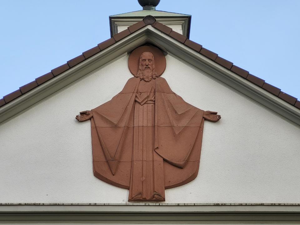 Fassadenelement aus Sandstein, Christus mit ausgebreiteten Armen.