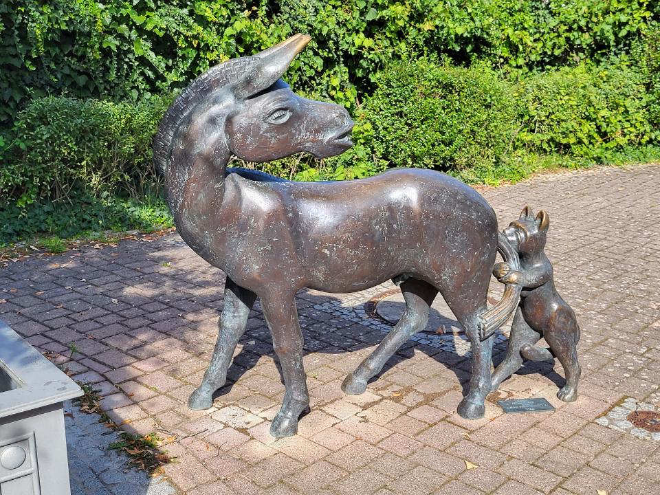 Figurengruppe aus Bronze, Esel und Katze.