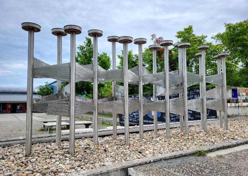 Brunnenskulptur aus 15 nebeneinander stehenden Röhren.