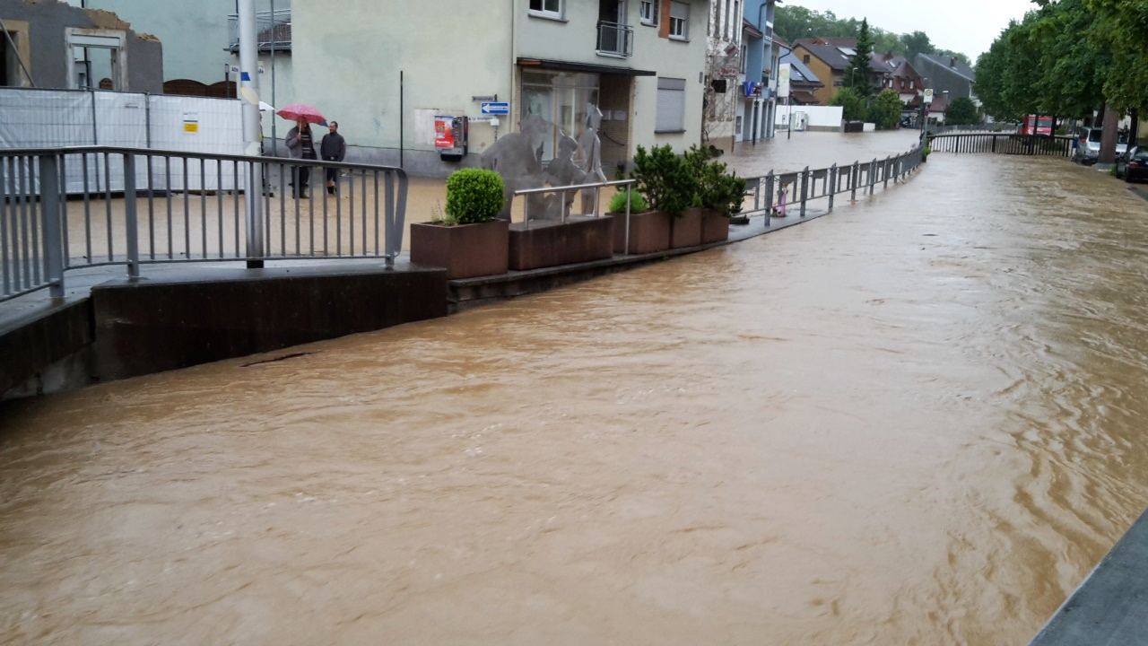 Der Angelbach tritt über die Ufer und überflutet die Alte Bahnhofstraße.