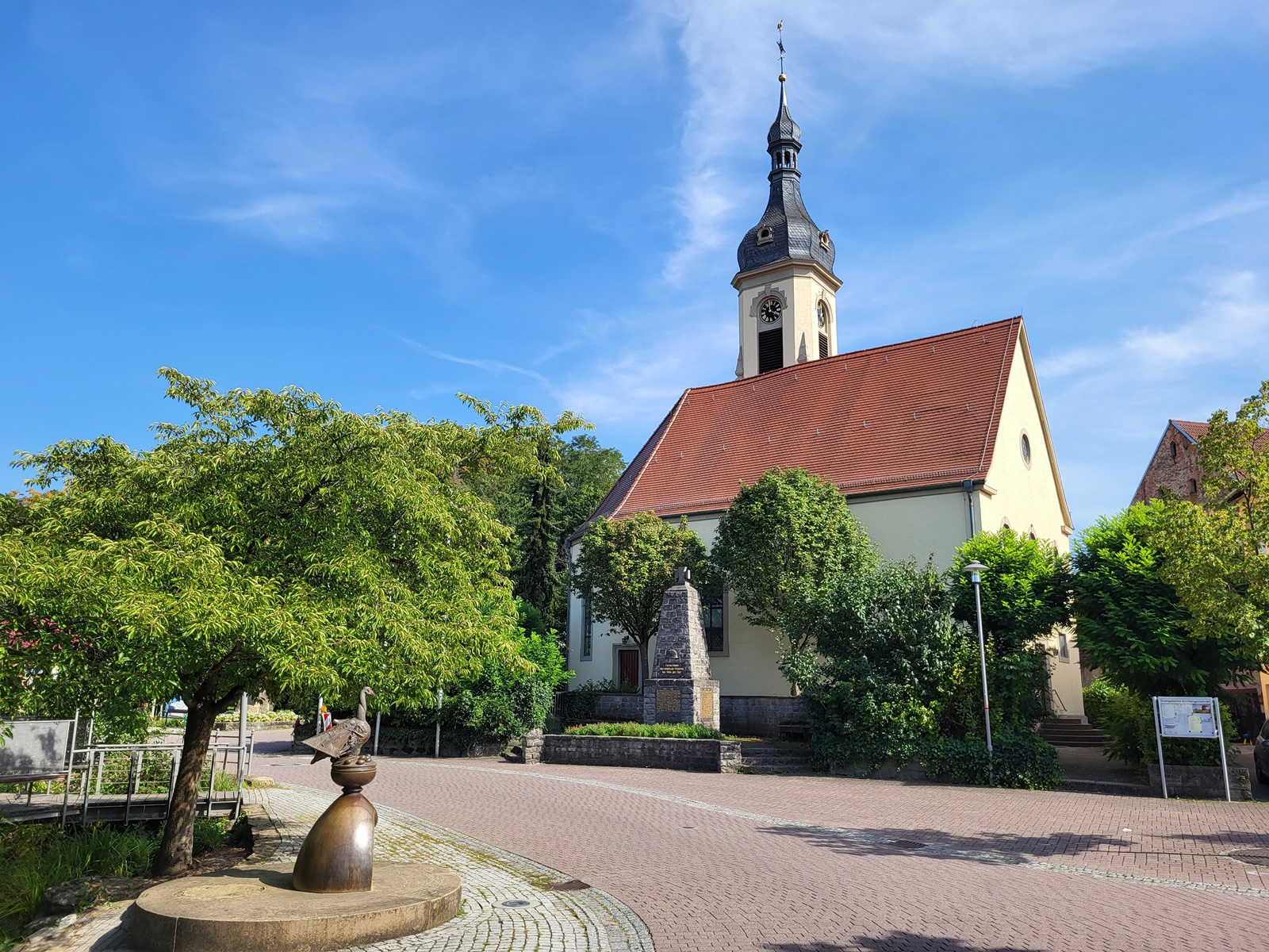 Dorfplatz in Schatthausen mit Evangelischer Kirche und Gänsebrunnen.
