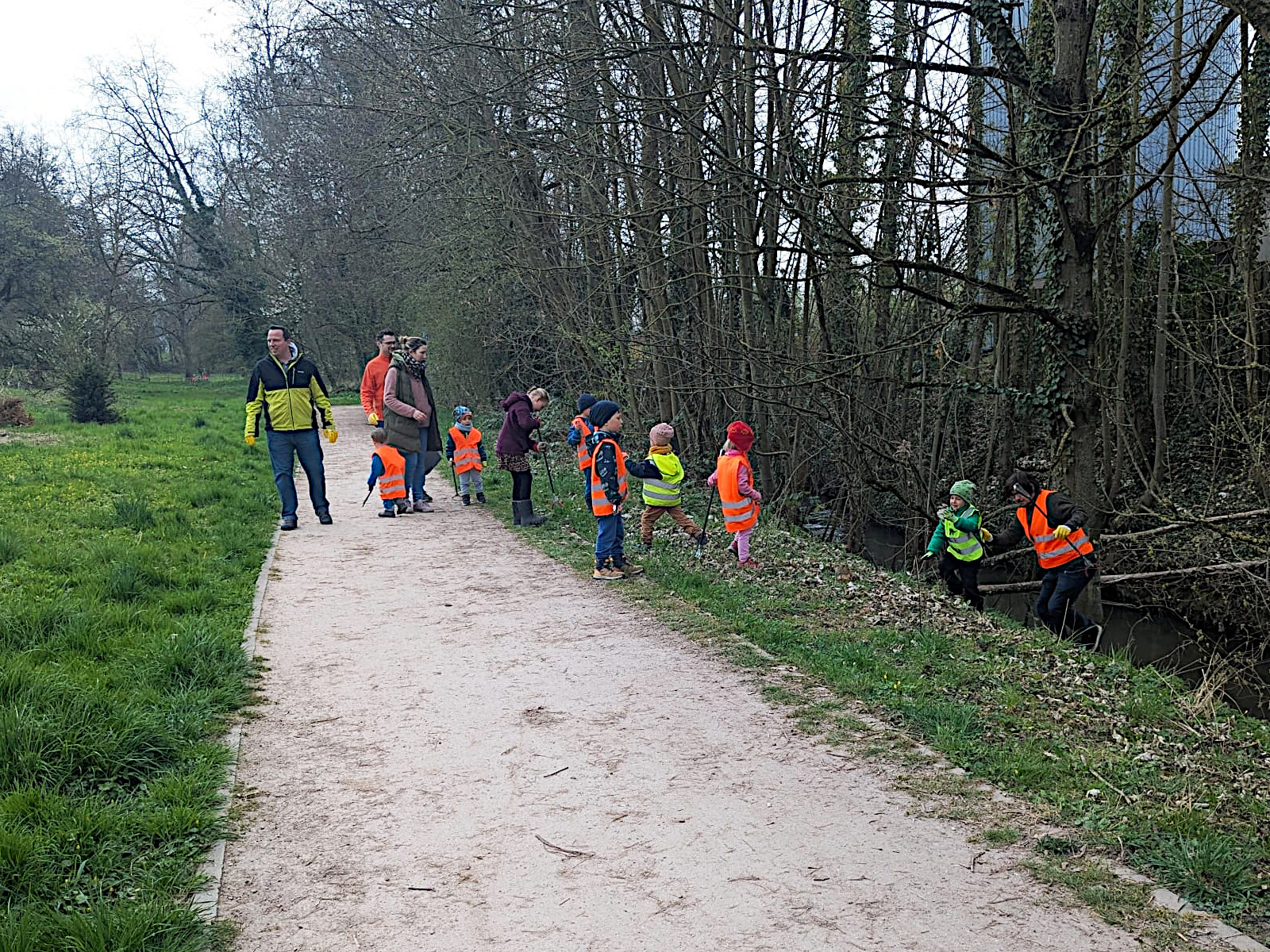 Kleine und große Menschen des Naturkindergarten Postillion e.V. sammeln Müll.