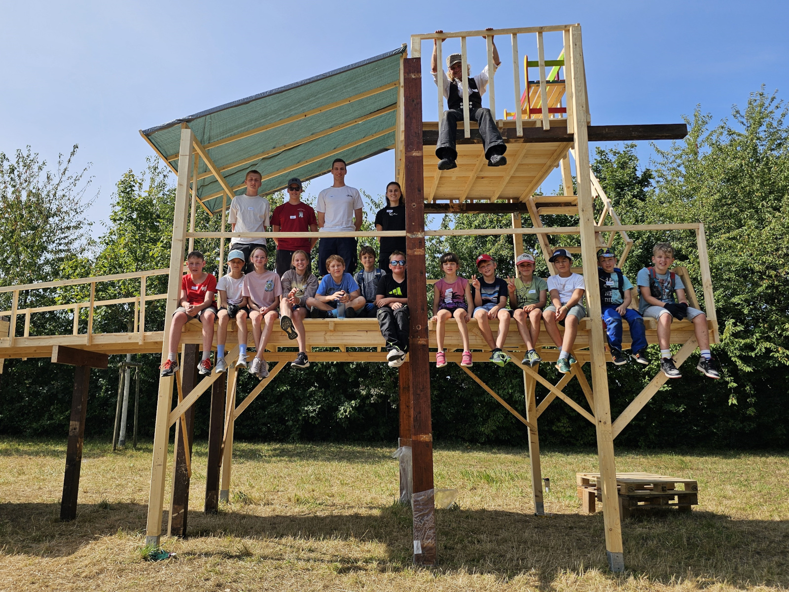 Kinder und Betreuende arbeiten gemeinsam auf der Kinderbaustelle.